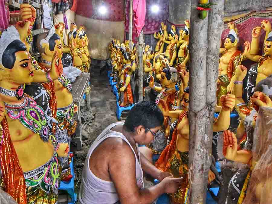 An artist gives finishing touches to Vishwakarma idols at Kumartuli ahead of Vishwakarma Puja which will be celebrated on September 18 