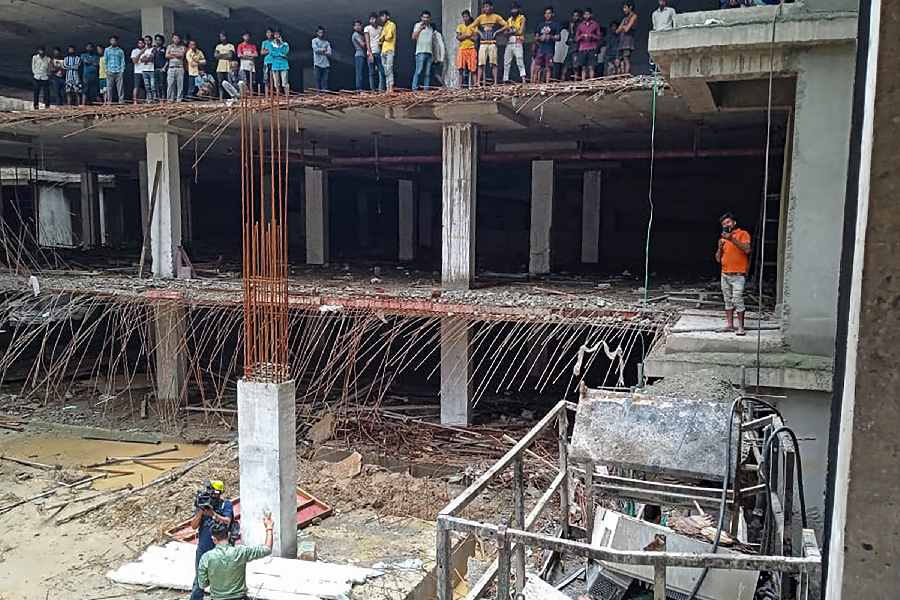 Locals at the site after a lift in an under-construction building collapsed, in Greater Noida