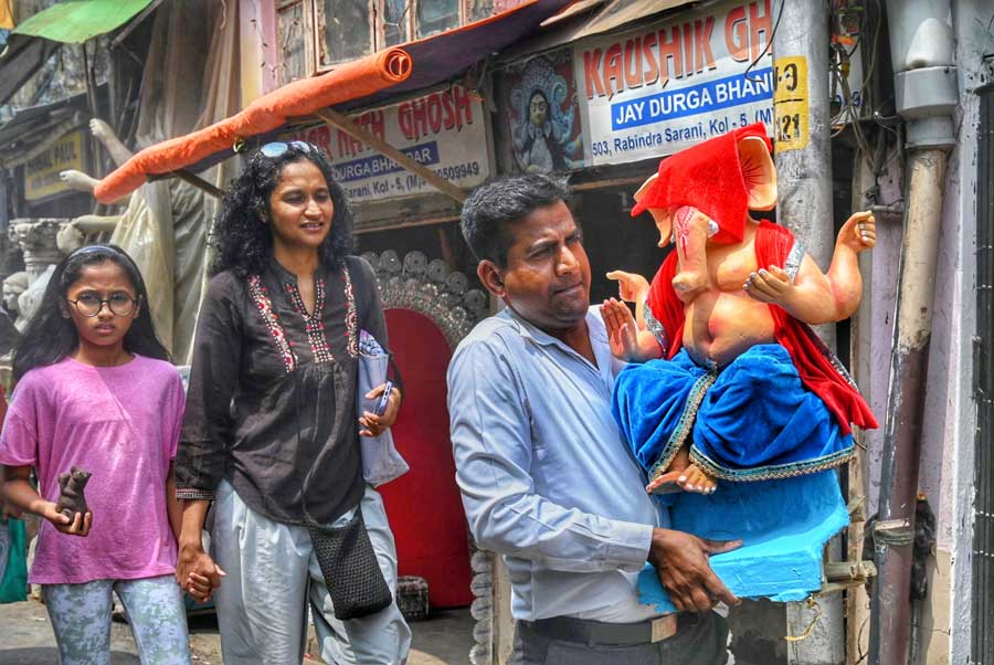 This family carries an idol of Lord Ganesh at Kumartuli on Monday 