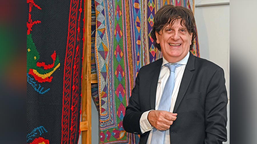 Didier Talpain takes a photo next to an intricately woven Saami quilt from India’s Kutch region
