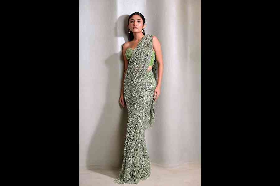 At a cocktail night or Diwali taash party, this contemporary green rhinestone sari is a head-turner. Paired with their signature beaded off-shoulder corset blouse, it is #totalwin