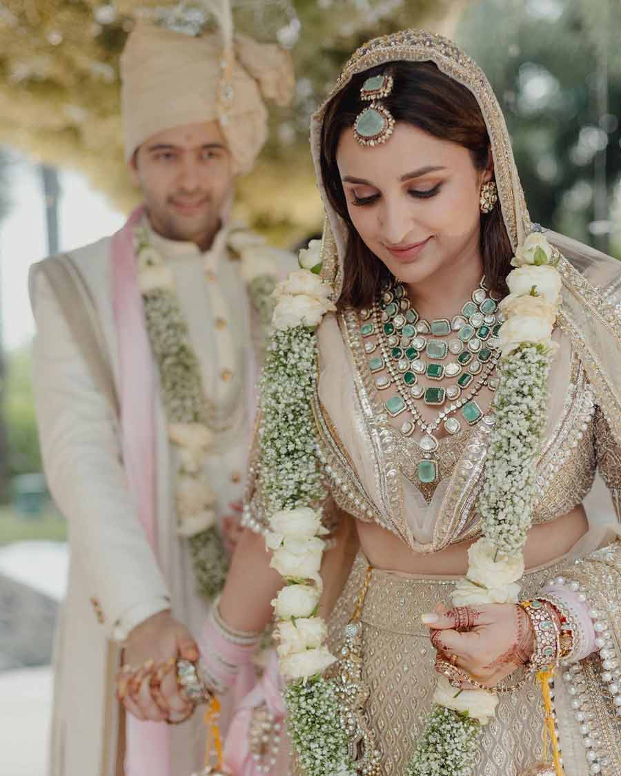 Parineeti went with a minimalistic bridal look and makeup, teaming her lehenga with a layered choker of uncut diamonds and green stones and a matching maangtika. 