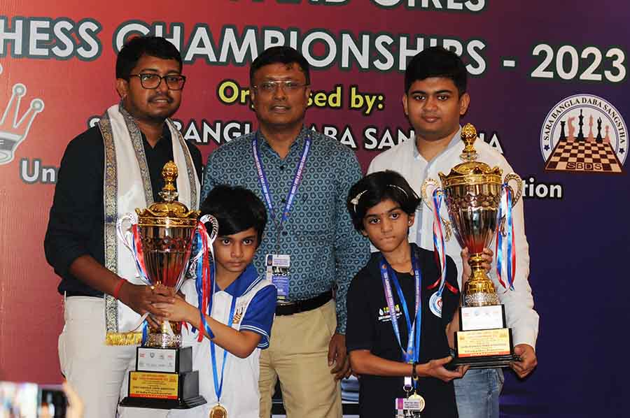 The 36th National U-7 Chess Championship Boys and Girls winners Sarbartho Mani and Narayani Umesh Marathe lift their trophies in the presence of grandmasters Sayantan Das, Dibyendu Barua and Diptayan Ghosh on Monday 