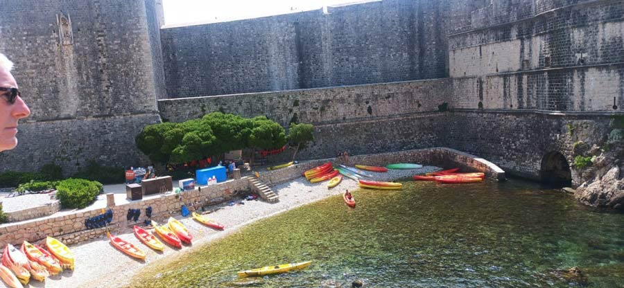 Kayaks wait for enthusiasts in shallow waters beside the fort