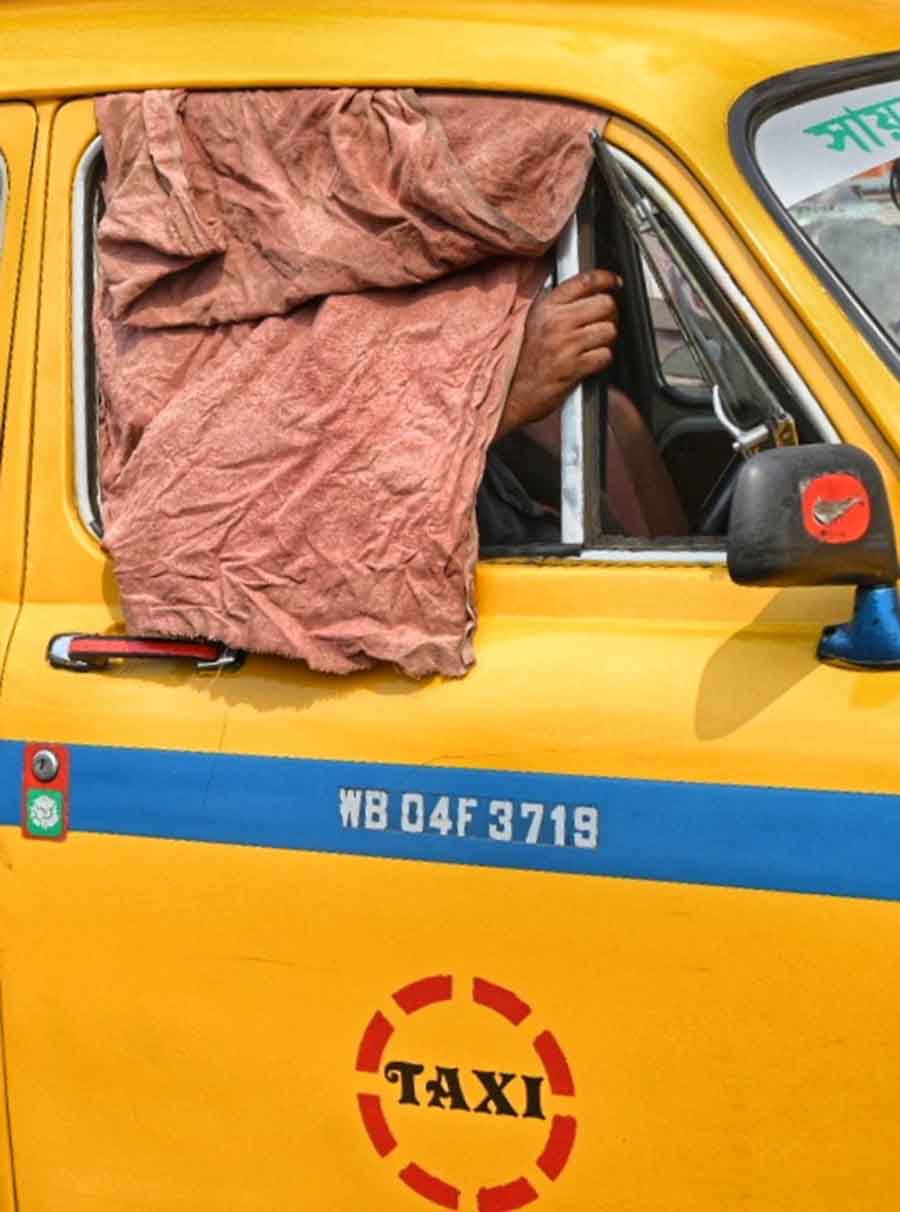 A cabbie improvised a ‘gamchha’ over the window of his vehicle as a sun shade  