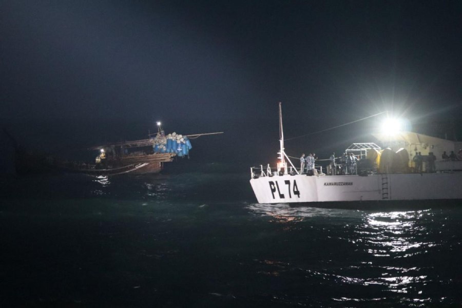 A Bangladesh Coast Guard ship (right) rescues the fishermen from the trawler on Thursday