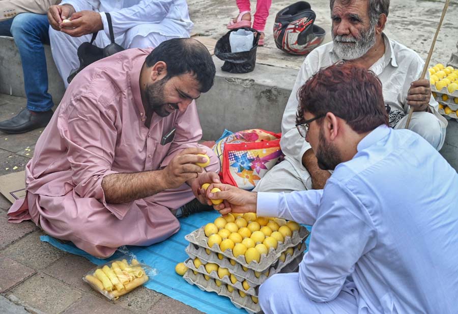 Two Afghan men play Hagey Jangawel, an egg fight popular in the community, on Eid. The one who ends up breaking the opponent’s egg wins the game  