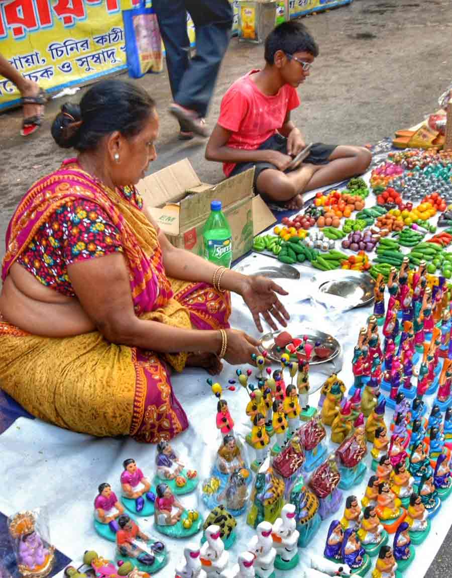 A woman sells clay statues, showpieces, tiny fruits and vegetables, all made of clay