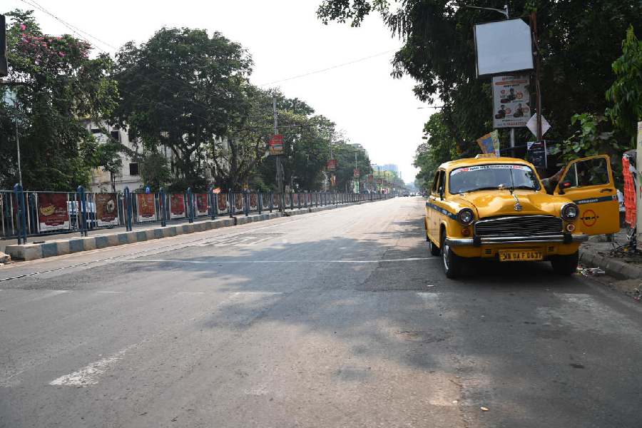 A taxi in the shade of a tree of an empty Rashbehari Avenue, near Priya Cinema, on Monday afternoon.