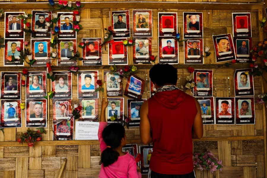 Kuki people look at photographs of those who they say have died in ethnic violence at a wall of remembrance memorial, in Churachandpur, Manipur, India, April 8, 2024.