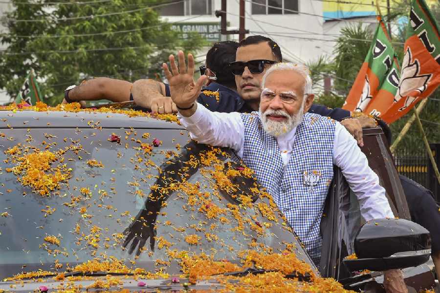 Prime Minister Narendra Modi waves to supporters upon his arrival for a public meeting, ahead of Lok Sabha elections