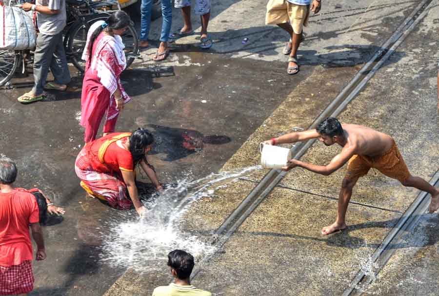 Devotees perform ‘Dondi kata’ ritual which is a part of Sitala Puja. People splash water on the streets to cool down the heat to facilitate devotees  