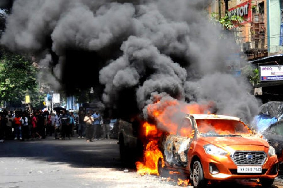 Black smoke rises from the Datsun Go that caught fire on Madan Street in Chandni Chowk on Thursday afternoon