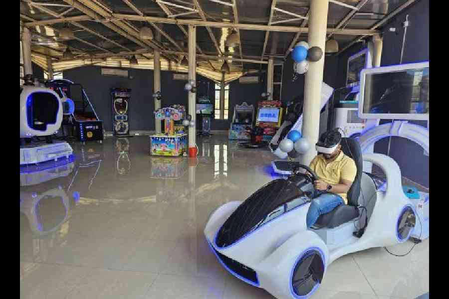 Two visitors tilted sideways in course of the VR 360 ride at Take-Off in Eco Park on the opening day. (Below) A visitor tries out his hand at the wheel of a car in a VR ride