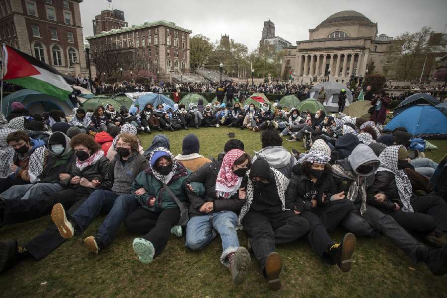 Pro-Palestinian demonstrators sit with locked arms amid their encampment on the South Lawn at Columbia University in New York, on Thursday afternoon, April 18, 2024.
