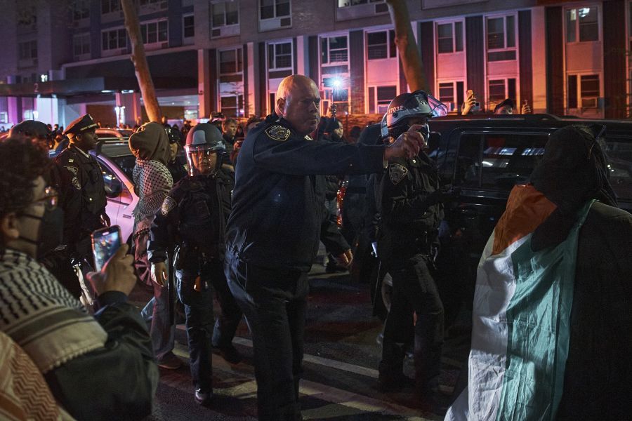 A police officer uses pepper spray on pro-Palestinian protesters at New York University in Manhattan, Monday night, April 22, 2024.