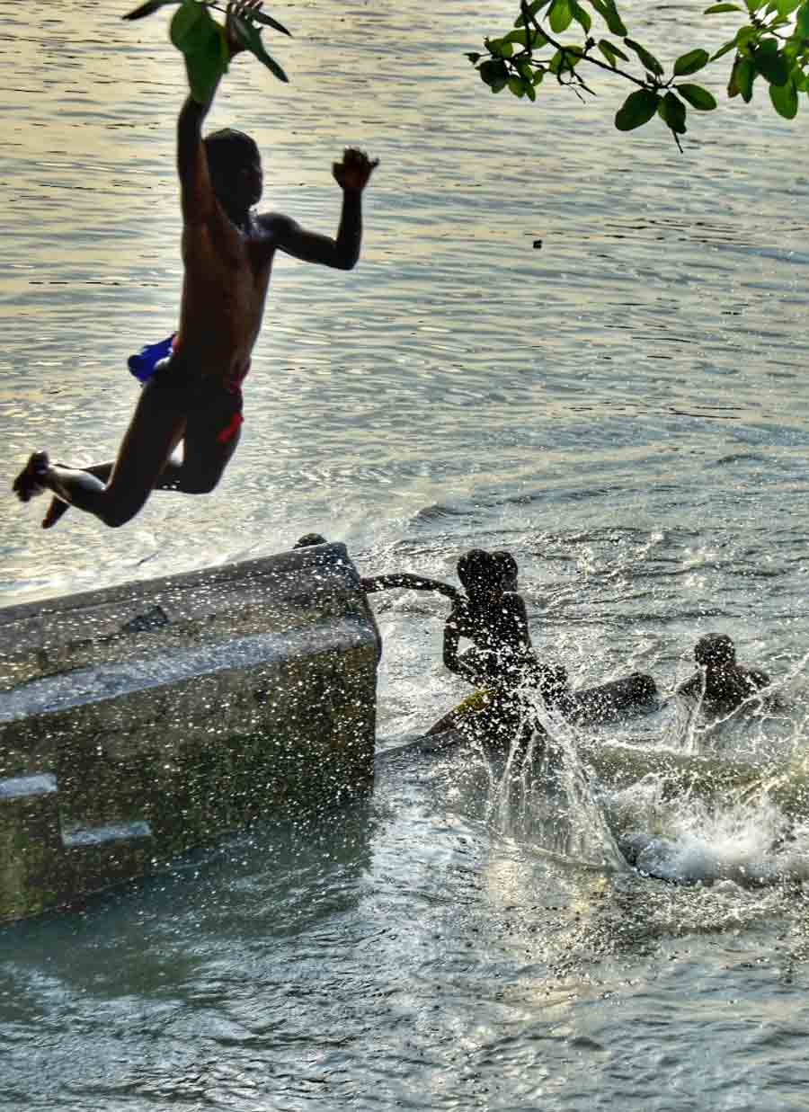 Boys dive into the Hooghly at Ahiritola Ghat