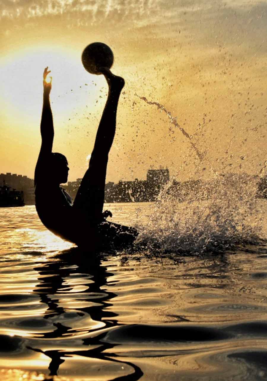 A boy enjoys a refreshing dip at the Hooghly river on a grimy Monday afternoon   