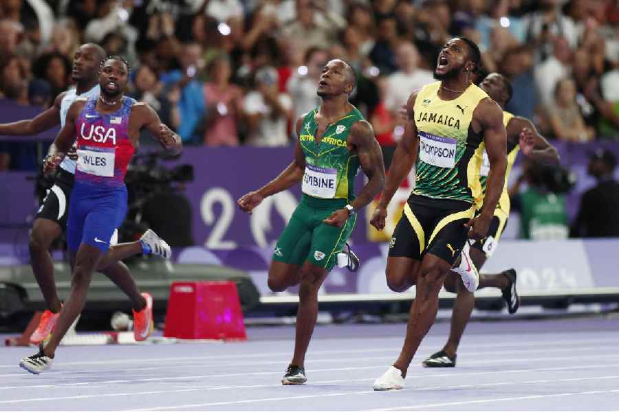 Kishane Thompson of Jamaica reacts as he crosses the line next to Akani Simbine of South Africa and Noah Lyles of United States who won gold