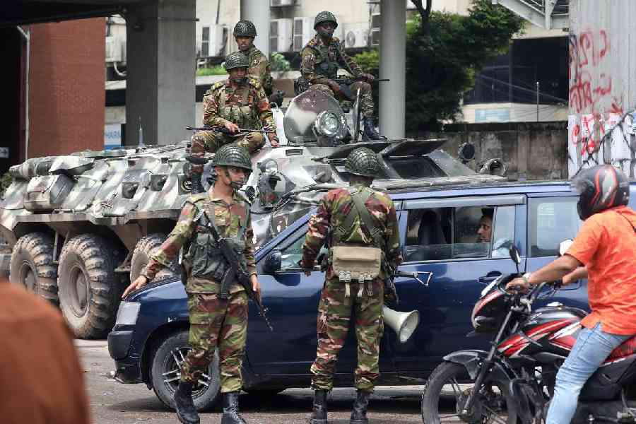 Bangladeshi Army soldiers patrol on the street after the government imposed a new curfew on Monday, in Dhaka, Bangladesh.