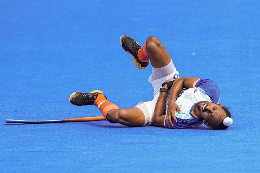 India's Hardik Singh lies on the ground after getting injured during the match