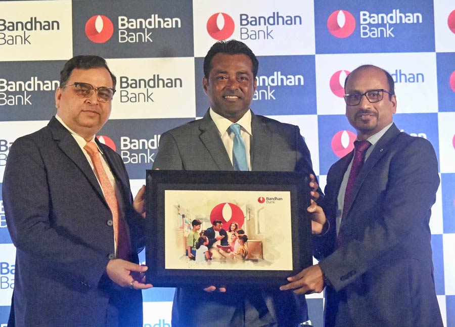 Bandhan Bank managing director and interim chief executive officer Ratan Kumar Kesh and executive director  and Rajinder Kumar Babbar hand over a memento to Leander Paes in Kolkata on Thursday to celebrate his induction in the International Tennis Hall of Fame  