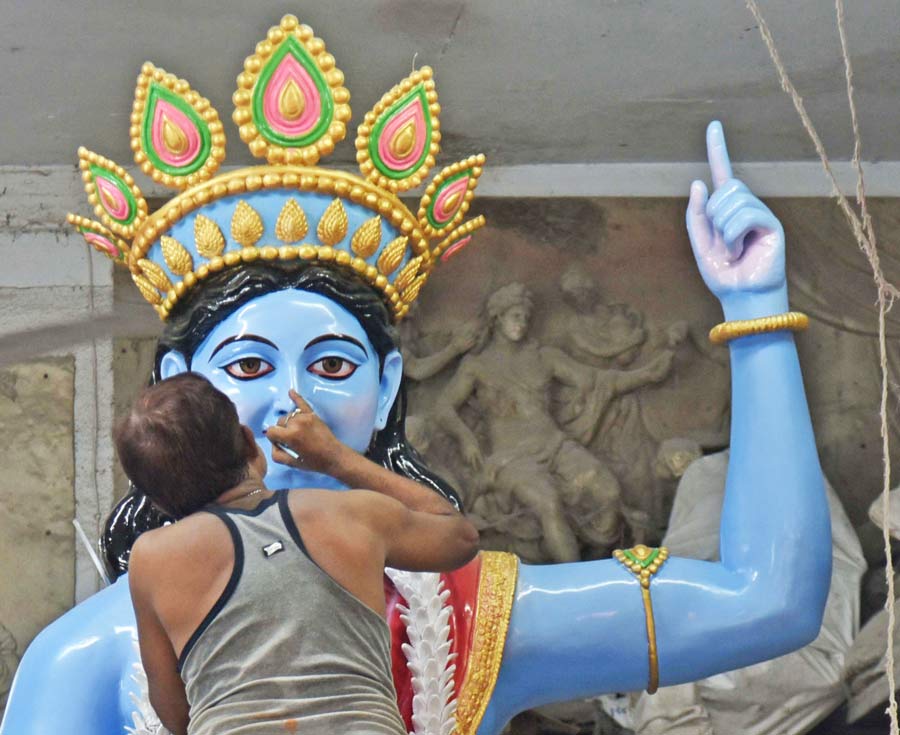 An artist lends finishing touches to an installation of Krishna at Kumartuli. These types of installations are put up at parks and other public places in the city for beautification