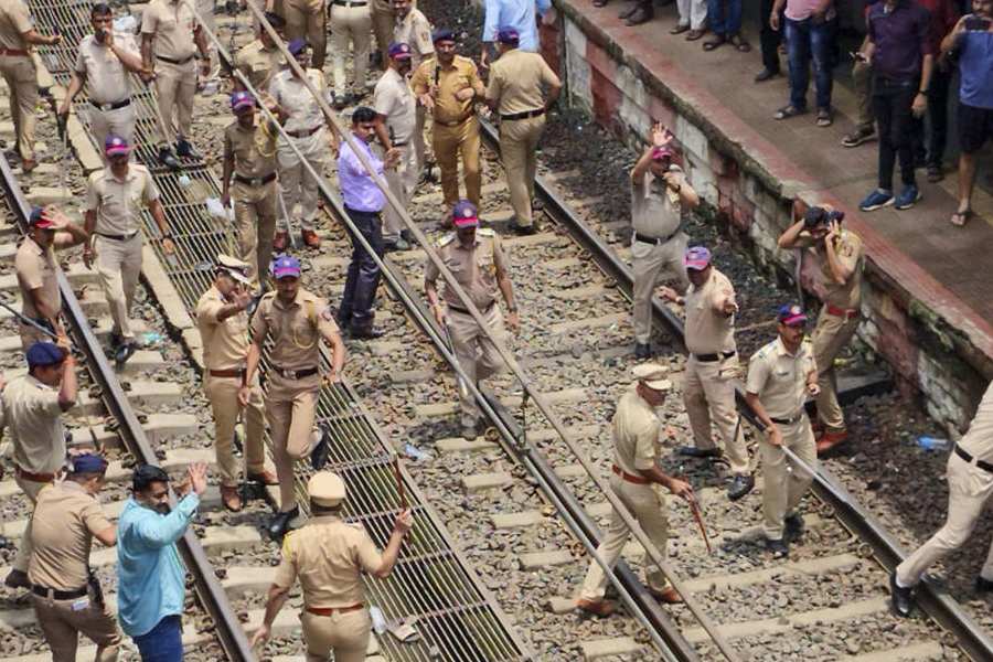 Police personnel try to disperse people blocking railway tracks in protest against the alleged sexual abuse of two girls at a school, at Badlapur railway station, in Thane district, Tuesday, Aug. 20, 2024.