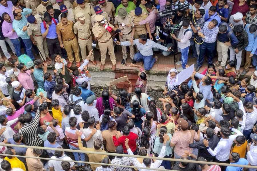 Police personnel speak with people blocking railway tracks in protest against the alleged sexual abuse of two girls at a school, at Badlapur railway station, in Thane district, Tuesday, Aug. 20, 2024. 