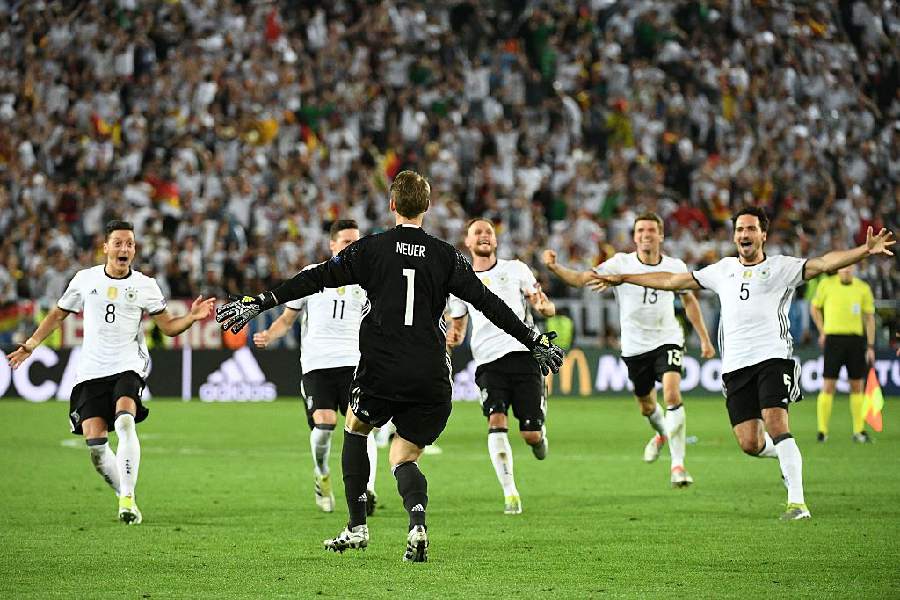 Manuel Neuer celebrates with his teammates after winning against Italy on penalties in 2016.