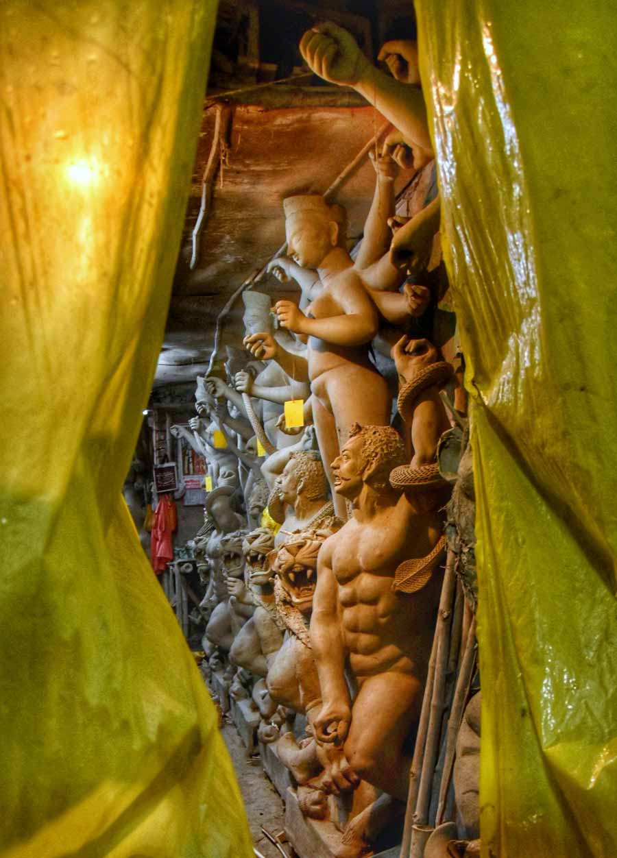 Polythene sheets protect idols of Durga and her children from rain at Kumartuli on Saturday 