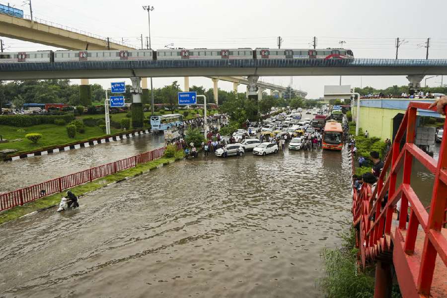 Commuters during a traffic jam on a waterlogged road after heavy rainfall, in New Delhi, Friday, Aug. 23, 2024.