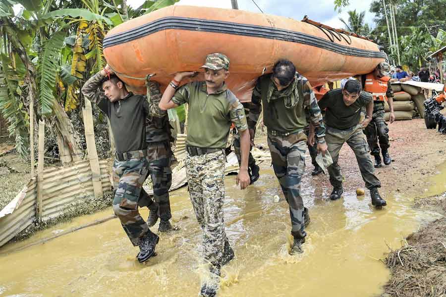 Security personnel are seen carrying a boat during a rescue and relief operation at flood-affected Amarpur area, in Gomati district, Monday, Aug. 26, 2024. 