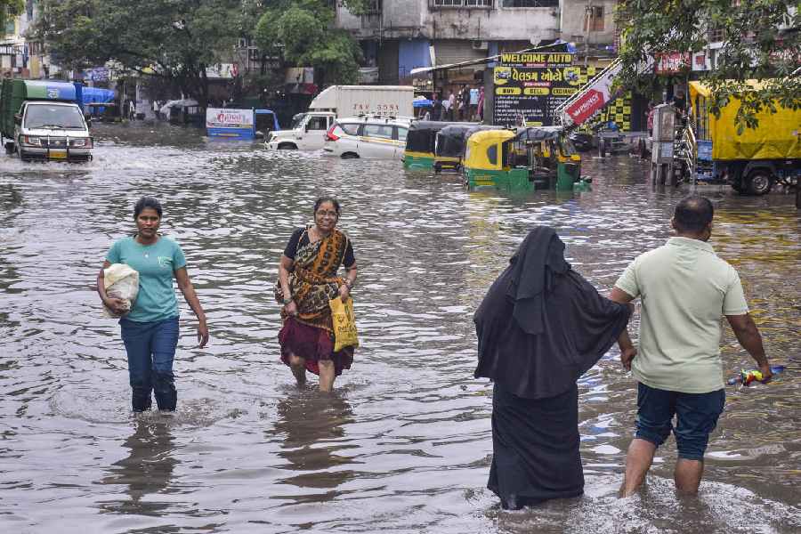 People wade through a waterlogged road at Ved Darwaja after heavy rainfall, in Surat, Tuesday. Aug. 27, 2024. 