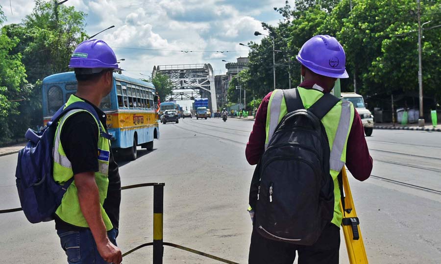 Railway Vikas Nigam Limited workers carry out survey work for Esplanade Mominpur Metro at the Hastings crossing