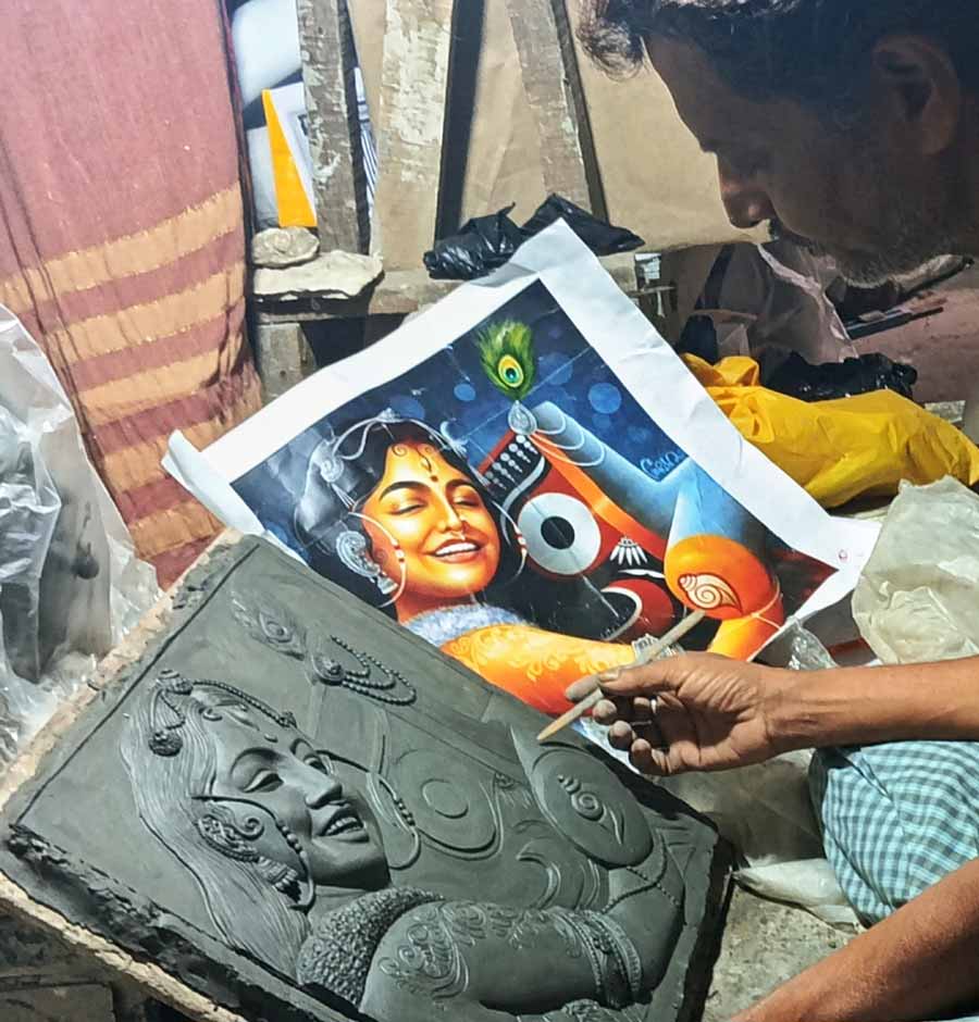 A miniature sculptor and clay model artist Amit Paul works in his studio at Kumartuli on Wednesday
