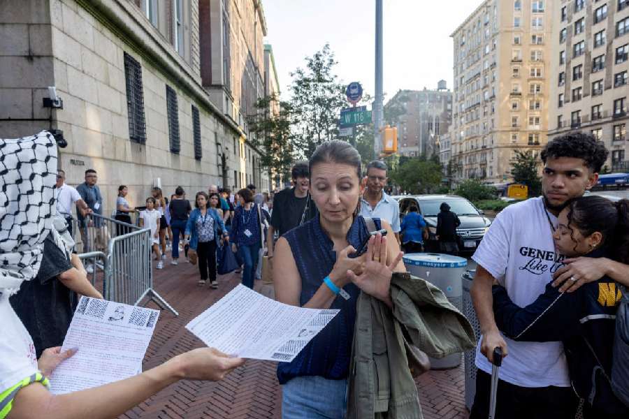 A woman refuses a flyer as protesters gather in front of Columbia University before convocation, at a main gated entrance of Columbia University, amid the ongoing conflict in Gaza between Israel and Hamas, in New York City, U.S., August 25, 2024. 