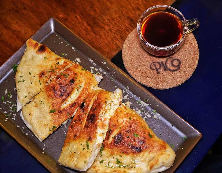 PICO Pizzeria and Coffee Bar, located near Vivekananda Park, has a whole tasting menu that will ensure you have a good time and a good meal with great company. The tasting menu is available for advance booking at Rs 2,000 per head for a minimum of six people and maximum of 15. The experience begins with their small plates. First up is a Calzone stuffed with ricotta cheese and pepperoni, paired with a marinara dipping sauce. They have you covered with a vegetarian version of the classic as well. Pair it with a spiced pourover — a heady mix of black coffee with cinnamon, black pepper and orange zest, delivering cosy Christmassy vibes ahead of the festive season