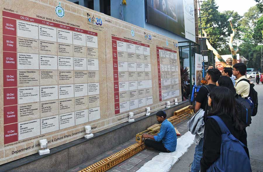 People check out the screening schedule of films for the Kolkata International Film Festival at the Nandan-Rabindra Sadan Complex on the eve of its inauguration. The fest will run from Wednesday to December 15, Sunday