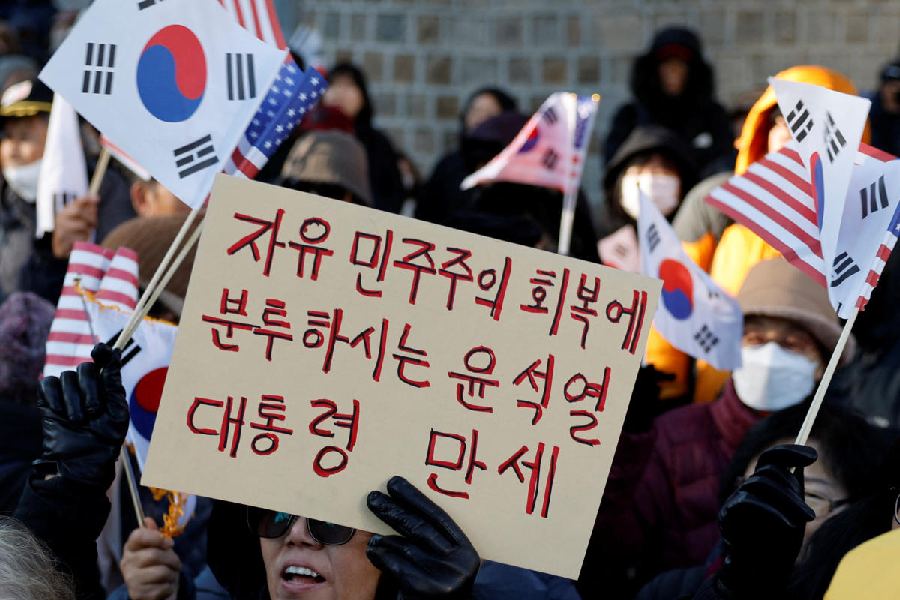 A protester holds a placard that reads "Long live President Yoon Suk-yeol, who is struggling to restore liberal democracy". 
