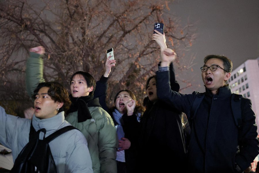 People shout slogans in front of the gate of the National Assembly, after South Korean President Yoon Suk Yeol declared martial law, in Seoul. 