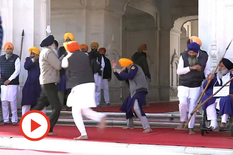 People catch a man who allegedly opened fire at Shiromani Akali Dal leader Sukhbir Singh Badal while the latter was serving the 'tankhah' (religious punishment) given by the Akal Takht at the Golden Temple, in Amritsar, Wednesday, Dec. 4, 2024.
