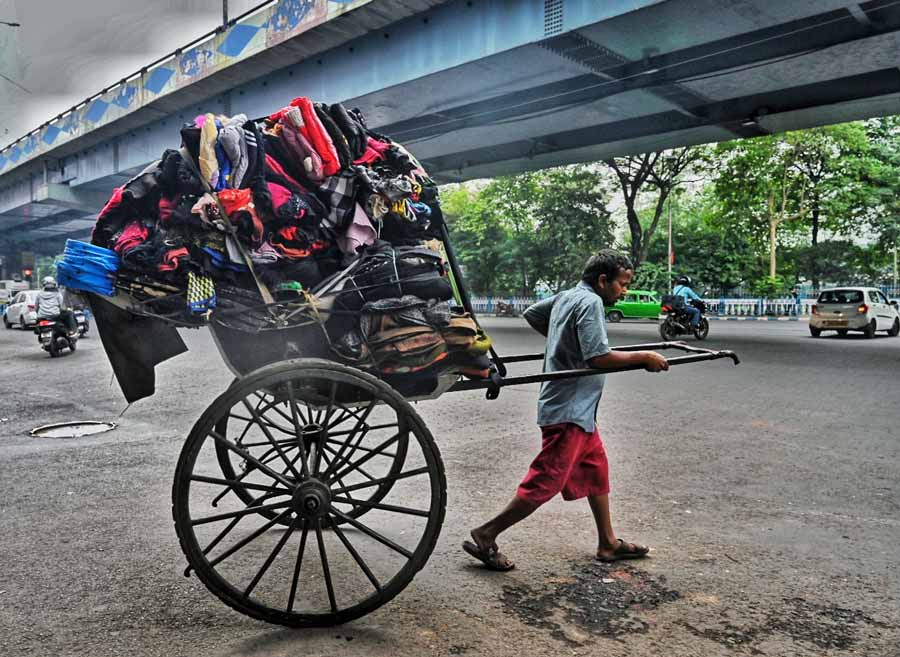 A rickshaw-puller carries a heap of woollens, reflecting the rising demand for winter wear to tackle the dipping mercury  