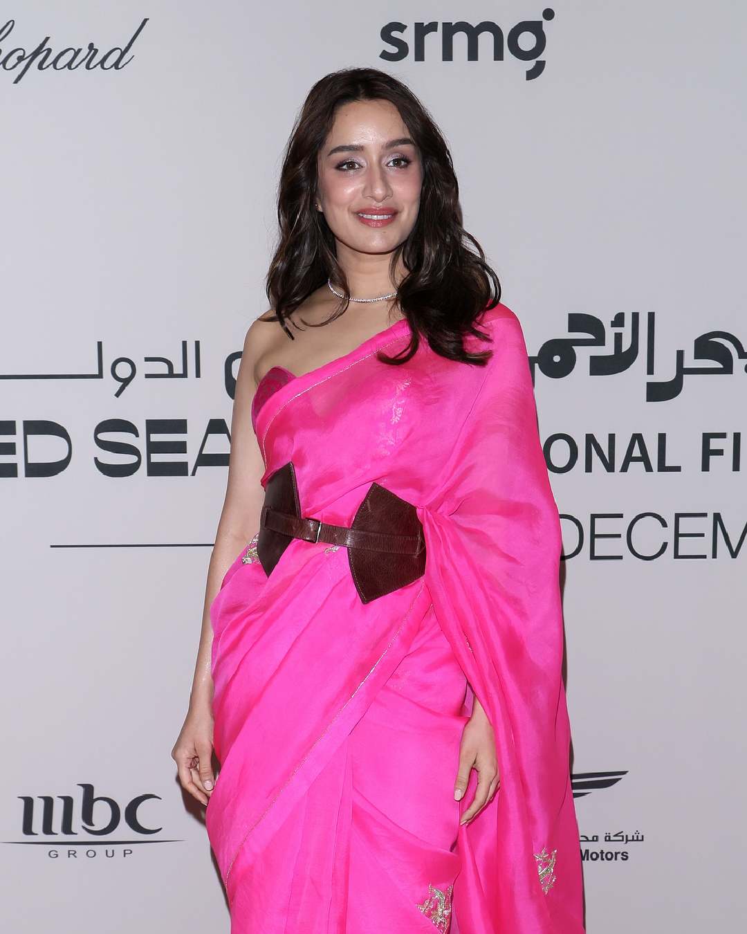 Shraddha Kapoor attended the interactive session in a vibrant pink sari paired with a corset blouse and a brown waist belt. 