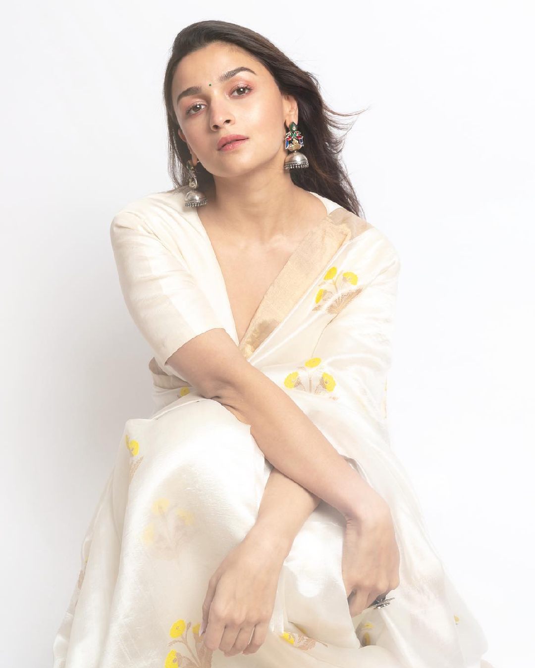 Alia Bhatt teamed a white organza sari with a blouse featuring a plunging neckline.