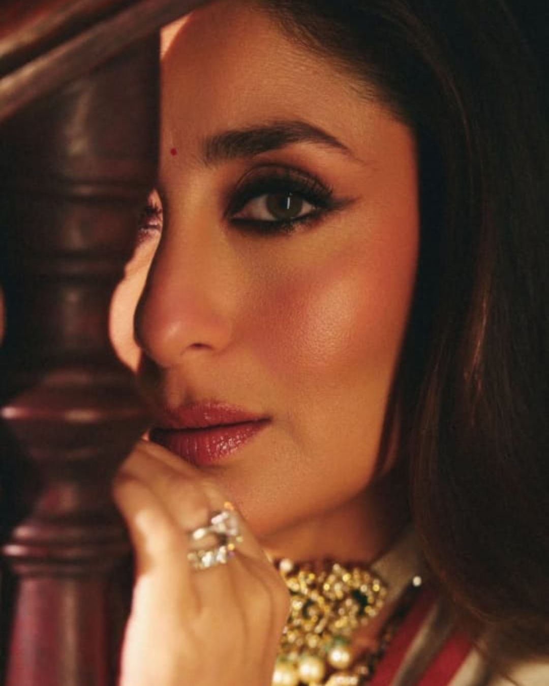 “Here’s looking at the next 100,” Kareena captioned a close-up portrait of herself. The actress looked radiant in an off-white sari with golden borders. For the makeup, she went for deep kohl eyes and coral lipshade. A chunky necklace and silver finger rings completed her look.