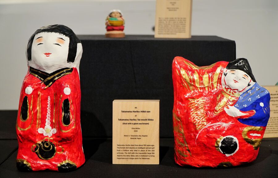 Takamatsu Hariko: Hoko-san and (right) Takamatsu Hariko: Tai-mochi Ebisu are paper dolls made by Ohita Mikiko. The Hoko-san dolls are modelled after a character from Japanese folklore named Omaki — a little servant girl who took on the illness of a princess and saved the royal’s life. The other doll with the fish is a depiction of deity Ebisu, who is worshipped by the fishing community for happiness and a bountiful catch