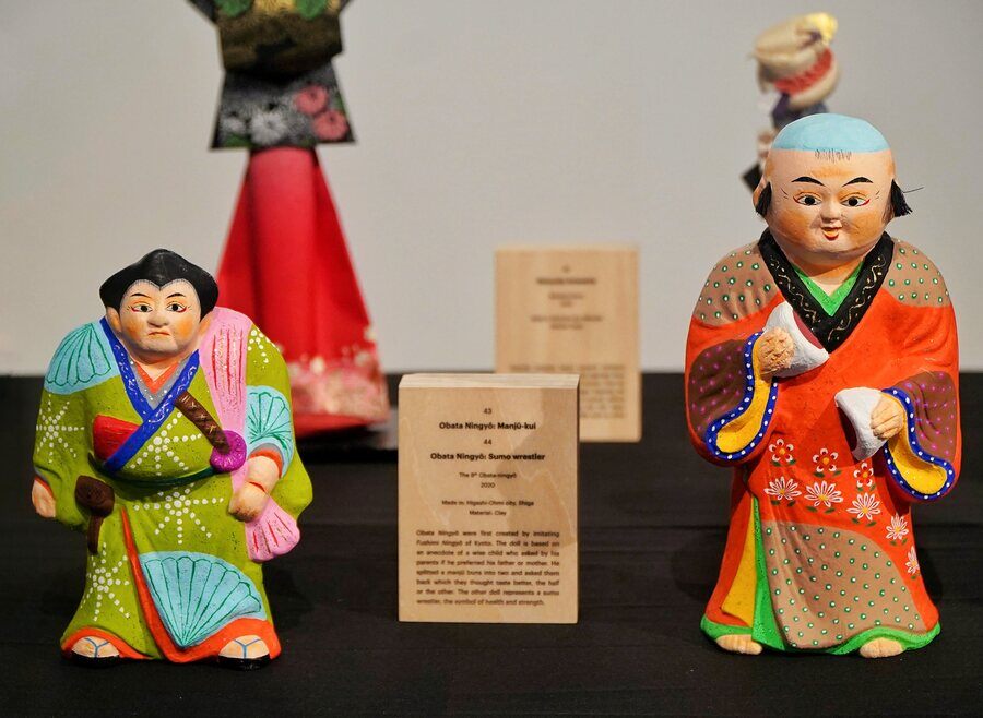 Obata Ningyo: Manju-kul and (right) Obata Ningyo: Sumo wrestlers are made with clay. Obata Ningyo was first created based on Fushimi Ningyo dolls and has a story attached to it. It is said that upon asking a child who he preferred more — his father or his mother — responded by splitting a manju bun (a traditional Japanese confectionery item) into two and asking his parents which piece tasted better. The sumo wrestler doll symbolises strength and health