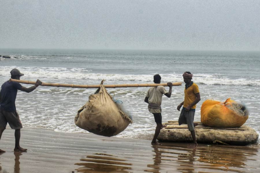 Fishermen transport fishing nets from the Bay of Bengal at Digha's Shankarpur on Friday