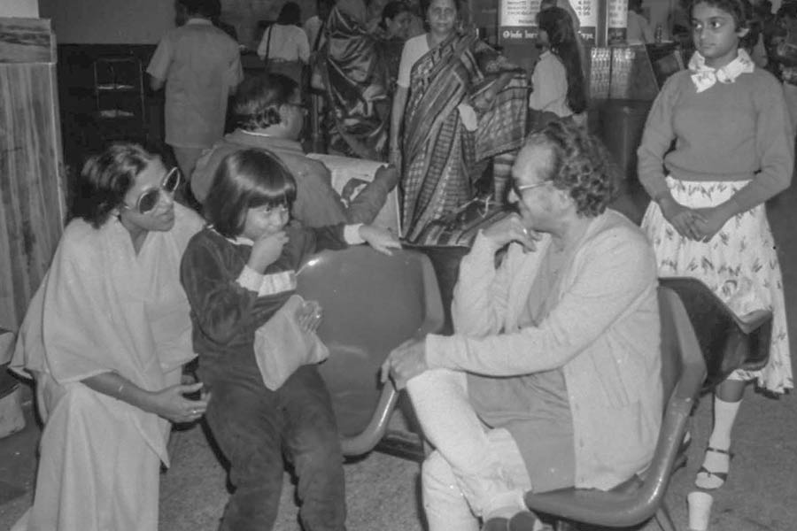Sitar maestro Pandit Ravi Shankar is caught in a candid photograph interacting with other fliers at Dum Dum airport sometime in the 1980s